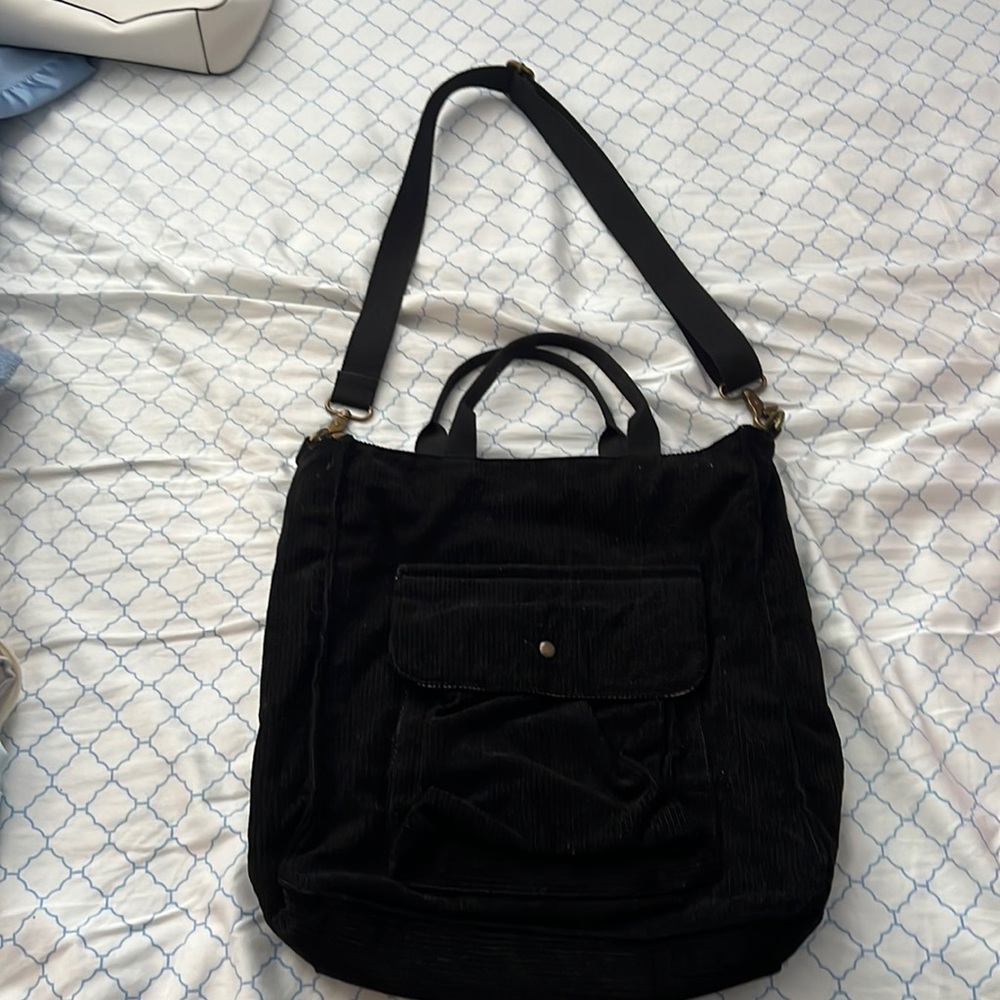 Black corduroy tote bag with top zipper.